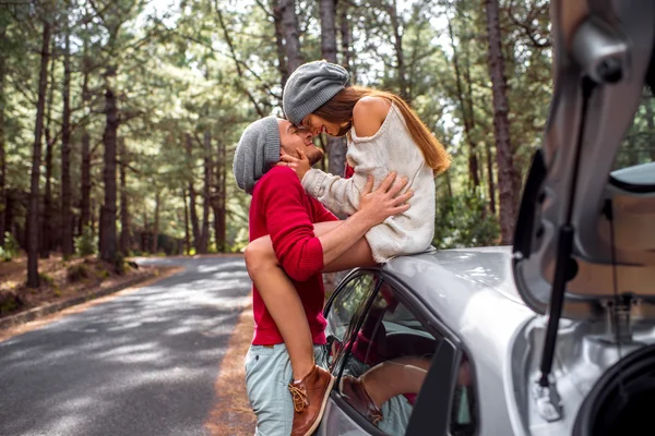 Young couple traveling by car in the forest — Stok fotoğraf