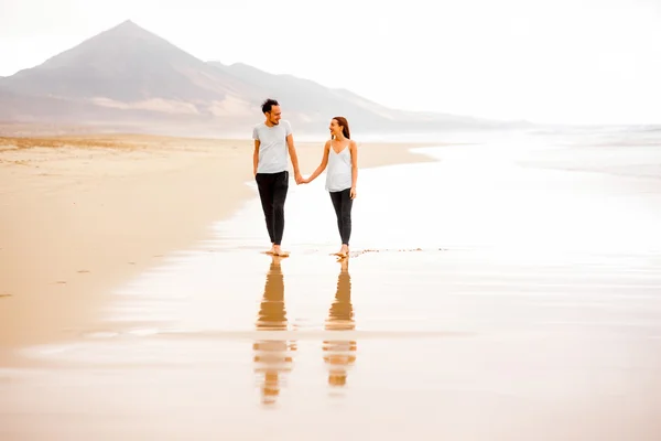 Пара прогулок по красивому пляжу — стоковое фото