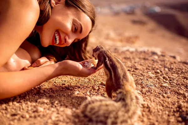 Mulher alimentando esquilo mourisco — Fotografia de Stock