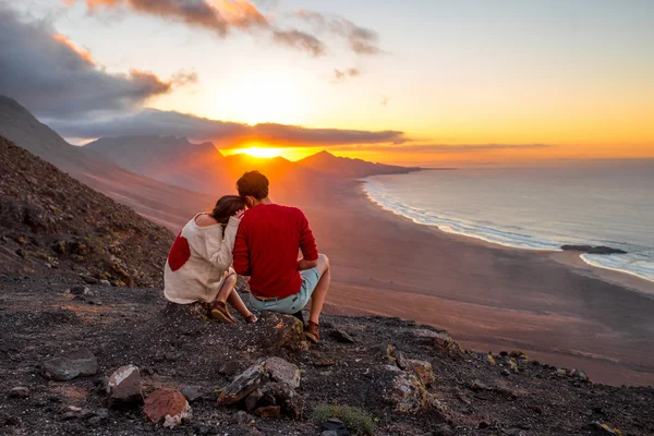 Pareja disfrutando de la hermosa puesta de sol en la isla de Fuerteventura —  Fotos de Stock