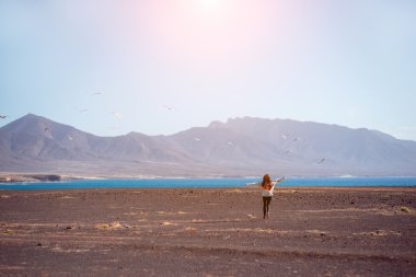 Carefree woman running on the deserted background