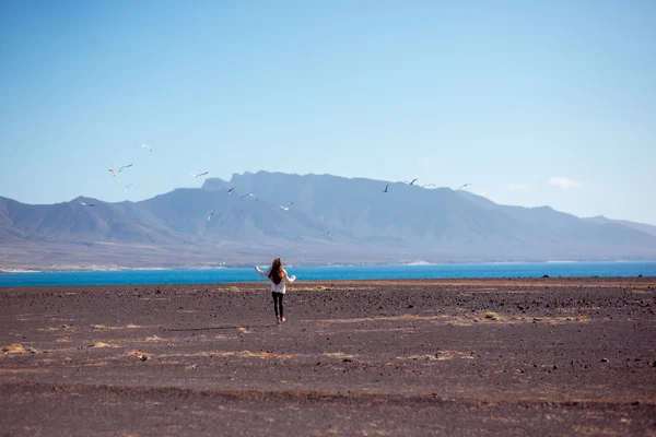 Carefree woman running on the deserted background — Φωτογραφία Αρχείου