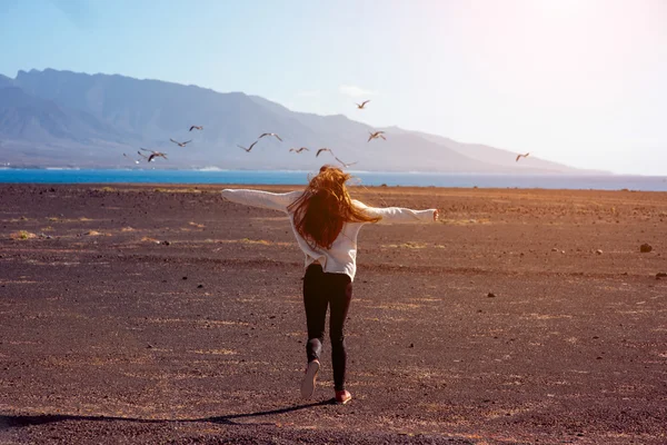 Carefree woman running on the deserted background — Stock Photo, Image