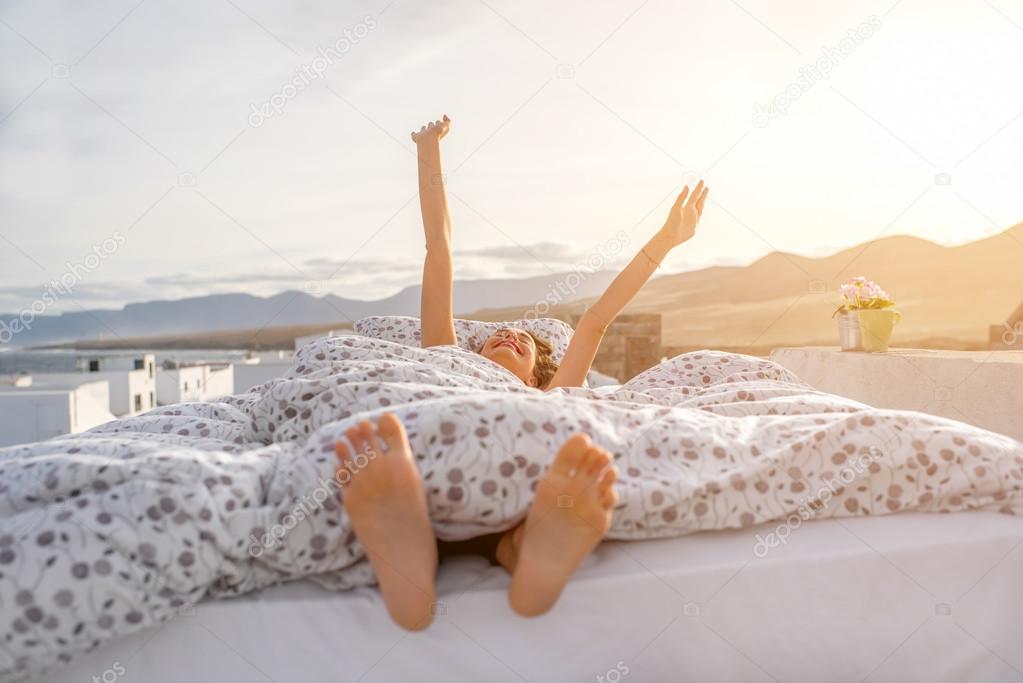 Woman waking up outdoors on the rooftop