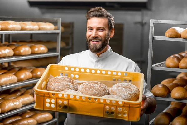 Padeiro segurando pães na fabricação — Fotografia de Stock