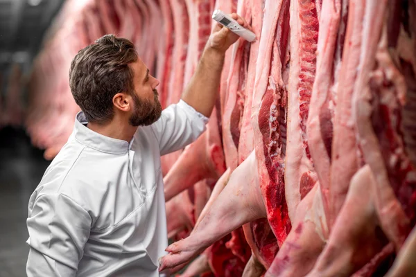 Slager meten van de tempratuur van varkensvlees — Stockfoto