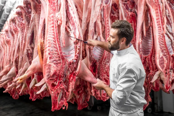 Slager snijden varkensvlees op de productie — Stockfoto