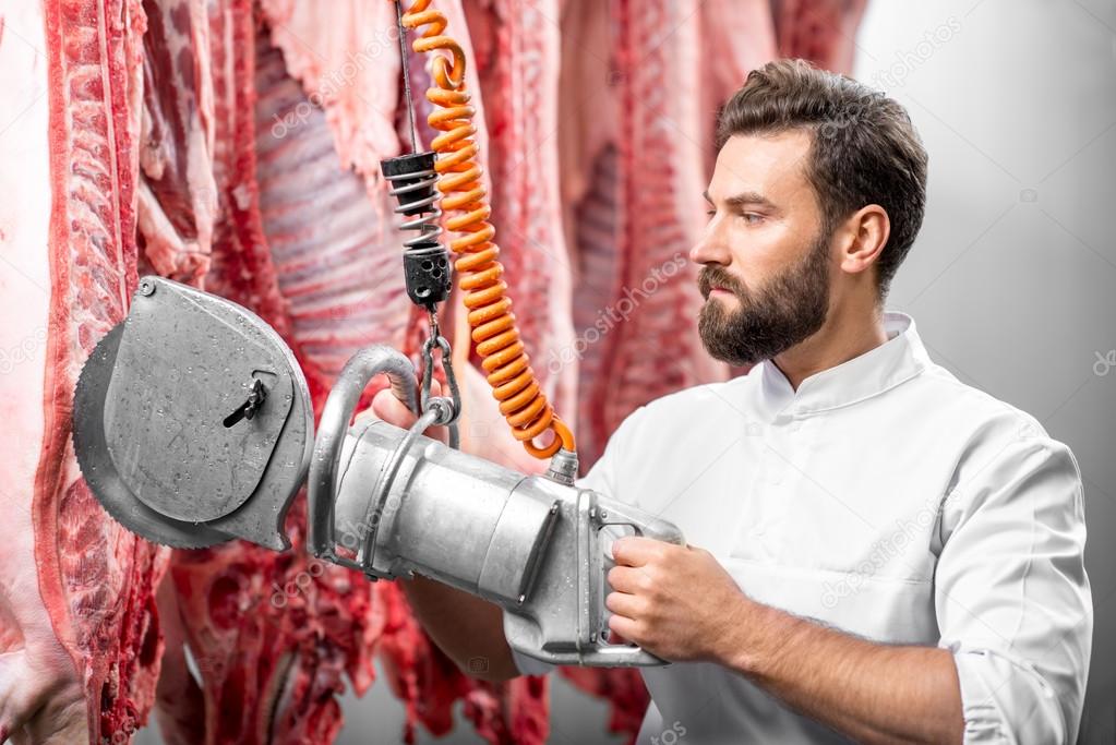 Butcher cutting pork at the manufacturing