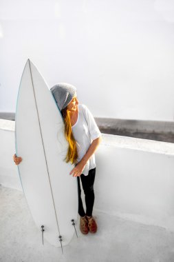 Kadın beyaz şehir arka plan üzerinde surfboard ile