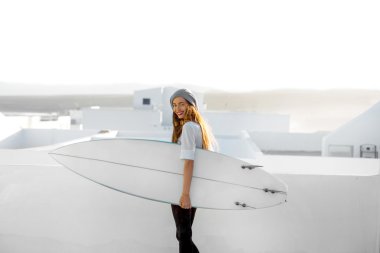 Kadın beyaz şehir arka plan üzerinde surfboard ile
