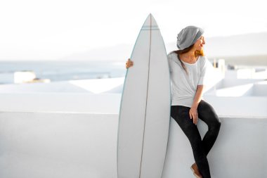 Kadın beyaz şehir arka plan üzerinde surfboard ile