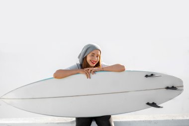Kadın beyaz şehir arka plan üzerinde surfboard ile