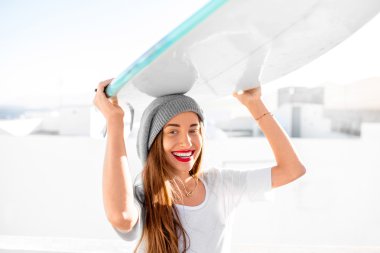 Kadın beyaz şehir arka plan üzerinde surfboard ile