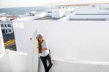 Kadın beyaz şehir arka plan üzerinde surfboard ile