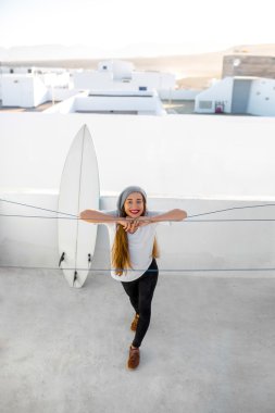 Kadın beyaz şehir arka plan üzerinde surfboard ile