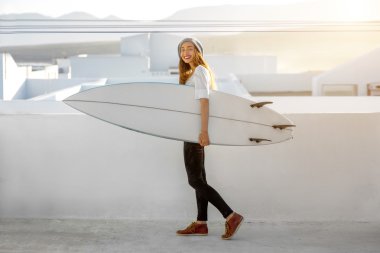 Kadın beyaz şehir arka plan üzerinde surfboard ile