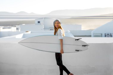 Kadın beyaz şehir arka plan üzerinde surfboard ile