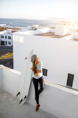 Kadın beyaz şehir arka plan üzerinde surfboard ile