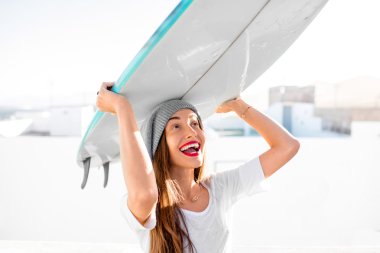 Kadın beyaz şehir arka plan üzerinde surfboard ile