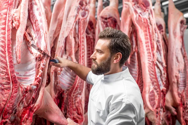 Slager snijden varkensvlees op de productie — Stockfoto