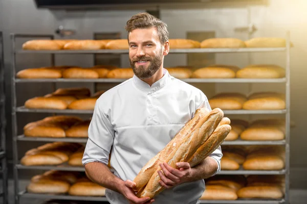 Baker houden stokbrood bij de productie — Stockfoto
