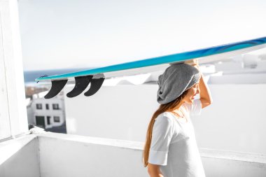 Kadın beyaz şehir arka plan üzerinde surfboard ile