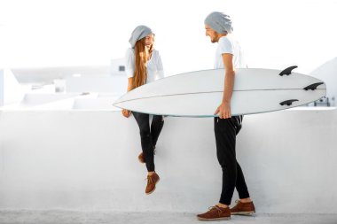 Açık havada beyaz zemin üzerine surfboard ile Çift