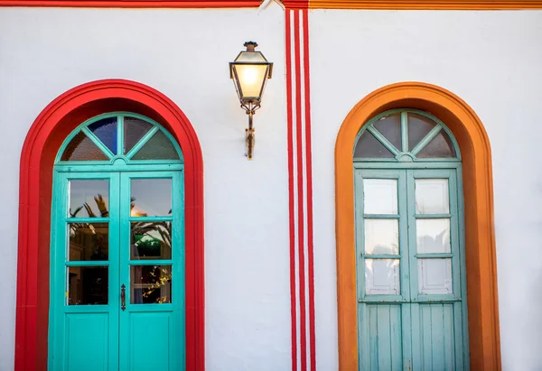 Pared blanca con puertas coloridas y linterna — Foto de Stock