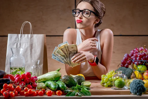 Woman with money cash and healthy food — Stock Photo, Image