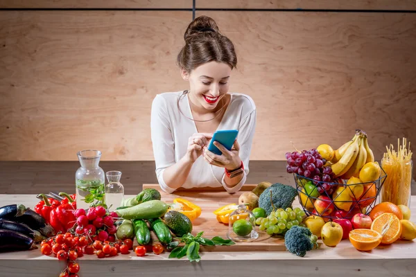 Meyve ve sebze mutfakta genç kadınla — Stok fotoğraf