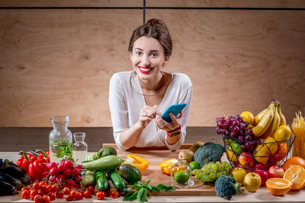 Meyve ve sebze mutfakta genç kadınla — Stok fotoğraf