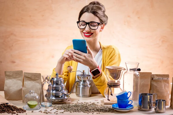 Cafetera joven usando teléfono inteligente — Foto de Stock