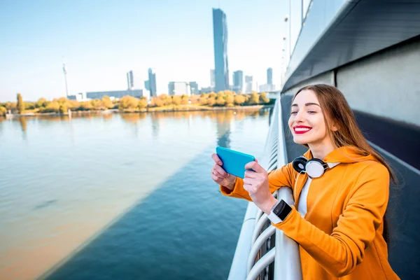Femme avec téléphone sur le pont moderne — Photo
