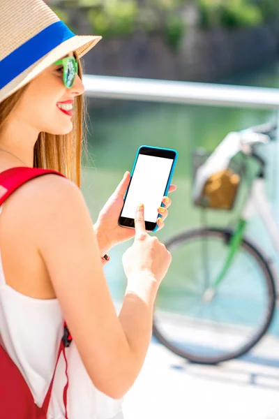 Viajero femenino sosteniendo teléfono con pantalla blanca al aire libre — Foto de Stock