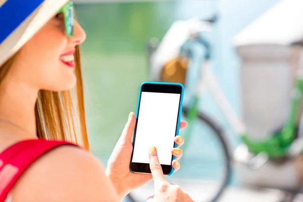 Feminino viajante segurando telefone com tela branca ao ar livre — Fotografia de Stock