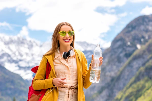 Vrouw drinknig water in de bergen — Stockfoto