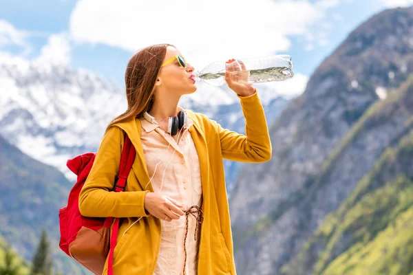 Kadın drinknig su dağlarda — Stok fotoğraf