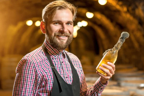 Sommelier med vinflaske i en kælder - Stock-foto