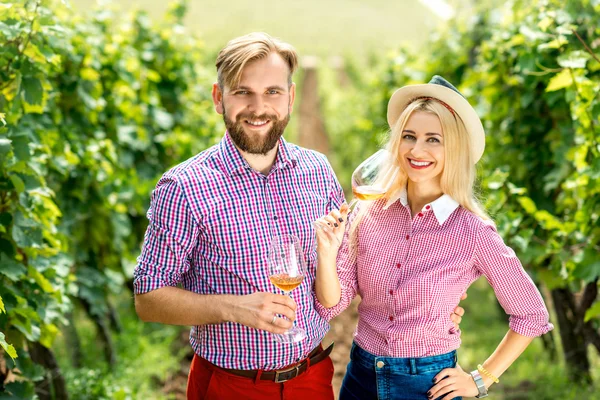 Couple s'amuser avec des verres de vin sur le vignoble — Photo