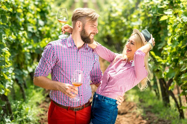 Пара веселится с бокалами вина на винограднике — стоковое фото
