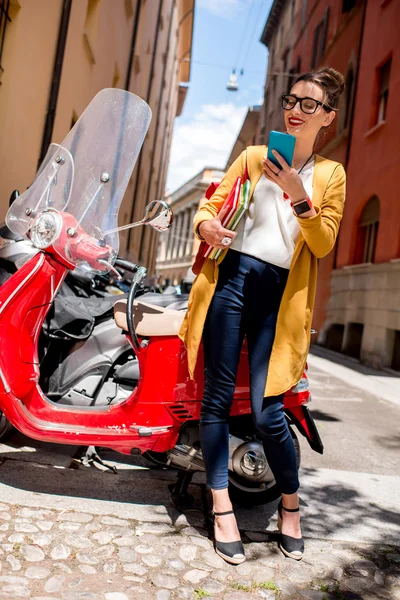 Estudiante cerca de scooter rojo en la ciudad — Foto de Stock