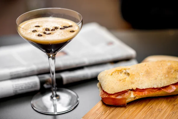 Shakerato drink with panini and newspaper. — Stock Photo, Image