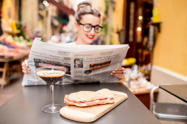 Mujer leyendo el periódico en el café al aire libre —  Fotos de Stock