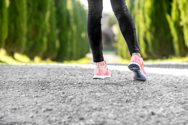 Patas femeninas en zapatillas deportivas —  Fotos de Stock