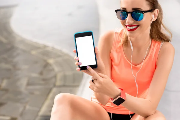 Spots mujer mostrando la pantalla del teléfono — Foto de Stock