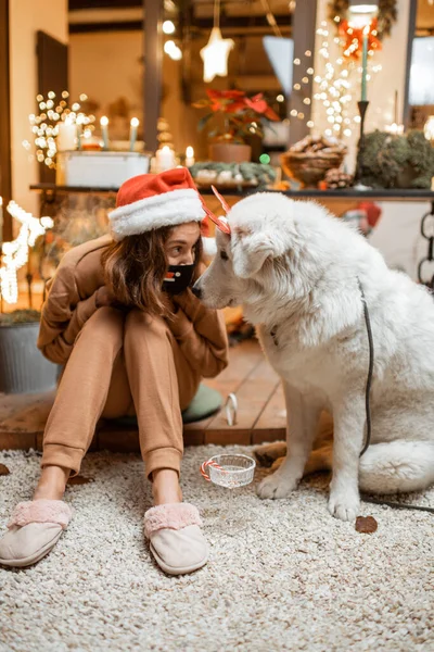 Femme sur l'auto-isolement célébrant les vacances du Nouvel An avec son chien à la maison — Photo