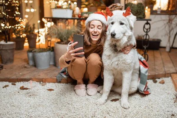 Vrouw viert met hond een nieuwjaarsvakantie thuis — Stockfoto