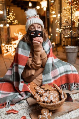 Kendi başına yaşayan bir kadın yeni yılı evde kutluyor.