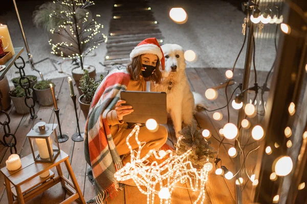 Vrouw viert met hond een nieuwjaarsvakantie thuis — Stockfoto