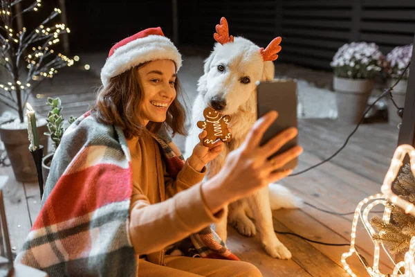 Vrouw viert met hond een nieuwjaarsvakantie thuis — Stockfoto